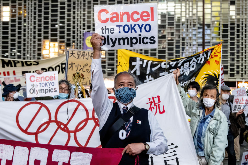  A protester holds a placard that says 'Cancel the Tokyo Olympics' during the demonstration.Demonstrators protest against the Tokyo Olympics with billboards and banners shouting 'Just stop it' marching through the Shimbashi and Ginza area. (Photo by Viola Kam/SOPA Images/LightRocket via Getty Images)