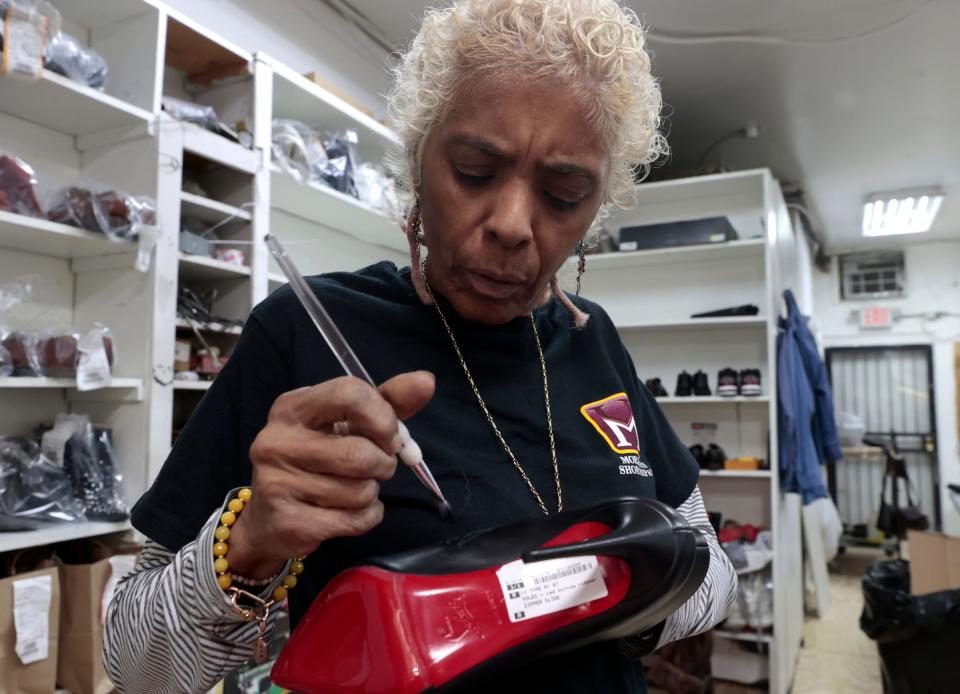 Ronda Morrison of the House of Morrison Shoe Repair on Livernois in Detroit works at adding black paint onto the buckle of a zipper for a customer’s shoe at her store on the Avenue of Fashion on Saturday, Nov. 18, 2023.