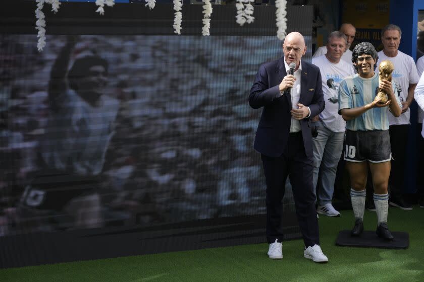 FIFA President Gianni Infantino speaks beside a statue of the late soccer star Diego Maradona during a commemoration in his honor in Doha, in Friday, Nov. 25, 2022. (AP Photo/Jorge Saenz)