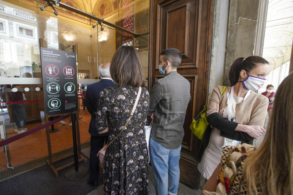 Visitors arrive on the reopening day of the Uffizi museum, in Florence, Italy, Wednesday, June 3, 2020. The Uffizi museum reopened to the public after over two months of closure due to coronavirus restrictions. (AP Photo/Andrew Medichini)