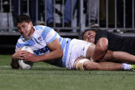 Samso Gonzalez of Argentina, left, scores a try despite the effort of New Zealand's Caleb Clarke during their Rugby Championship test match in Christchurch, New Zealand, Saturday, Aug. 27, 2022. (Martin Hunter/Photosport via AP)