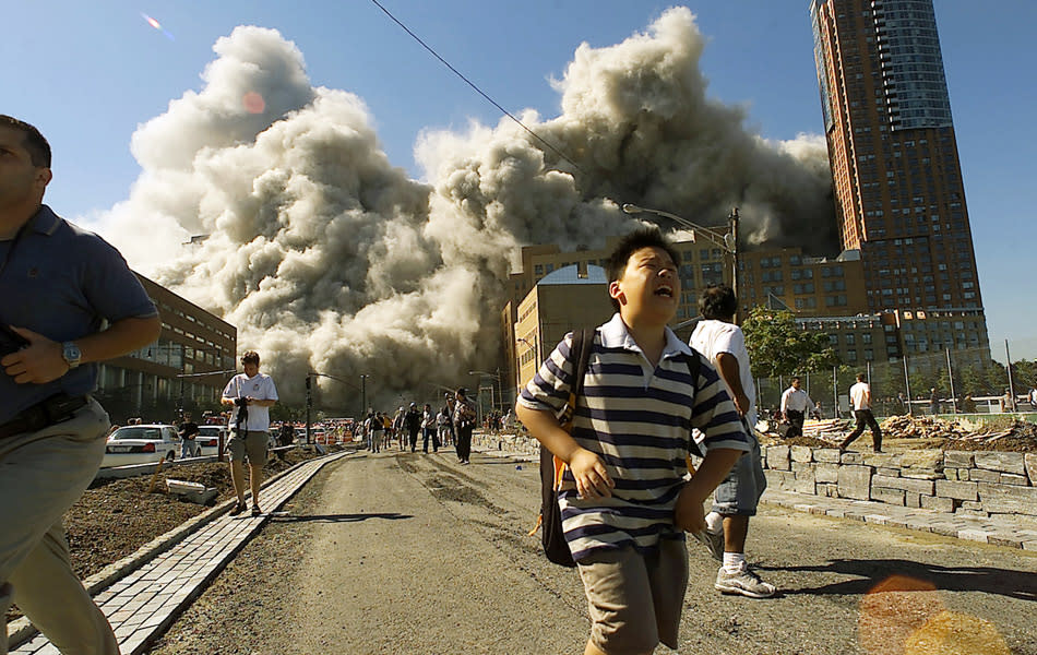 People run away as the second tower of World Trade Center crumbles down after a plane hit the building September 11, 2001 in New York City. (Photo by Jose Jimenez/Primera Hora/Getty Images)