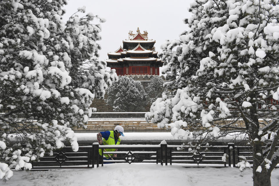 En esta imagen, distribuida por la agencia noticiosa estatal de China, Xinhua, un trabajador retira la nieve cerca de una Torre de la Ciudad Prohibida tras una intensa nevada, en Beijing, el 21 de febrero de 2024. (Ju Huanzong/Xinhua vía AP)