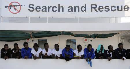 FILE PHOTO: Migrants wait to disembark from the Aquarius ship in the Sicilian harbour of Palermo, Italy October 13, 2017. REUTERS/Guglielmo Mangiapane