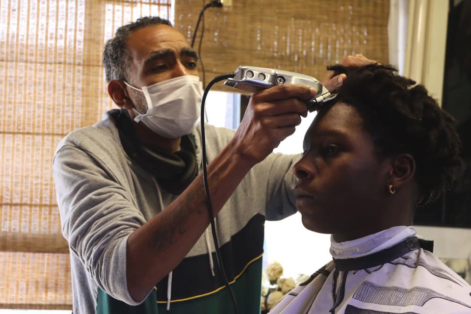 Simon Wallace cuts a customer's hair at 28th Street Barber Shop, which he's owned in Parkland for 15 years.