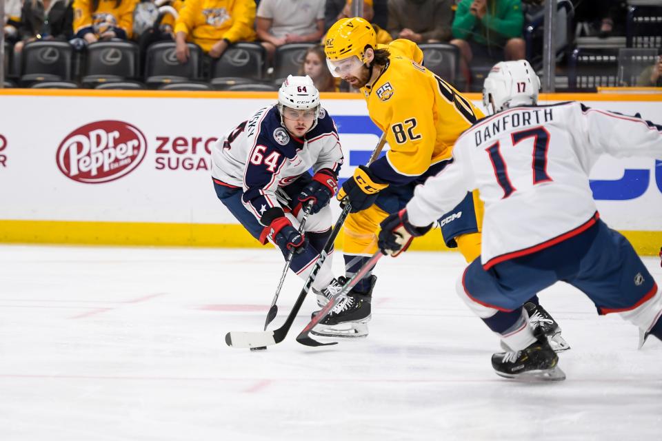 Apr 13, 2024; Nashville, Tennessee, USA; Nashville Predators center Tommy Novak (82) splits Columbus Blue Jackets right wing Trey Fix-Wolansky (64) and right wing Justin Danforth (17) during the third period at Bridgestone Arena. Mandatory Credit: Steve Roberts-USA TODAY Sports