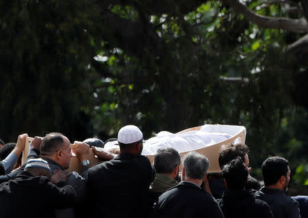 The body of a victim of the mosque attacks is carried during the burial ceremony at the Memorial Park Cemetery in Christchurch, New Zealand March 20, 2019. REUTERS/Jorge Silva