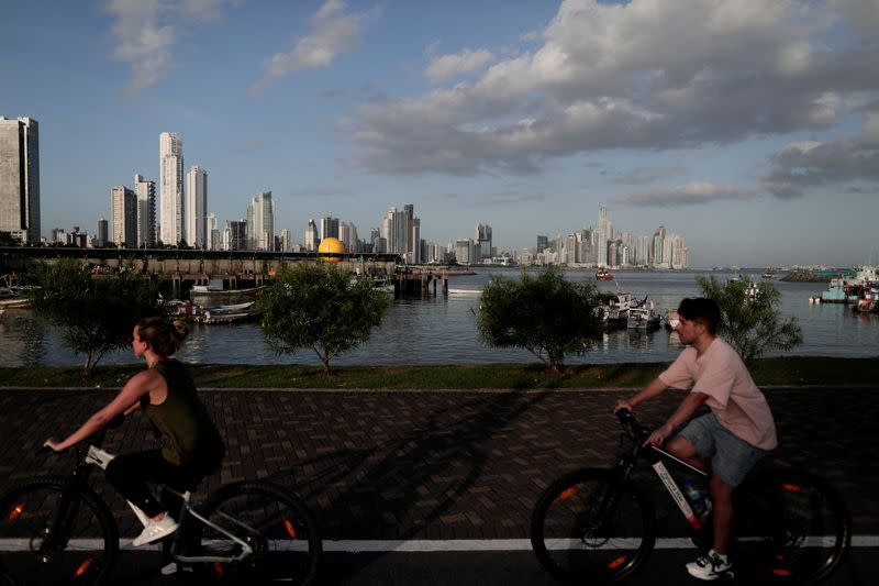 FILE PHOTO: People ride their bicycles, while the Panama City's skyline is visible in the background