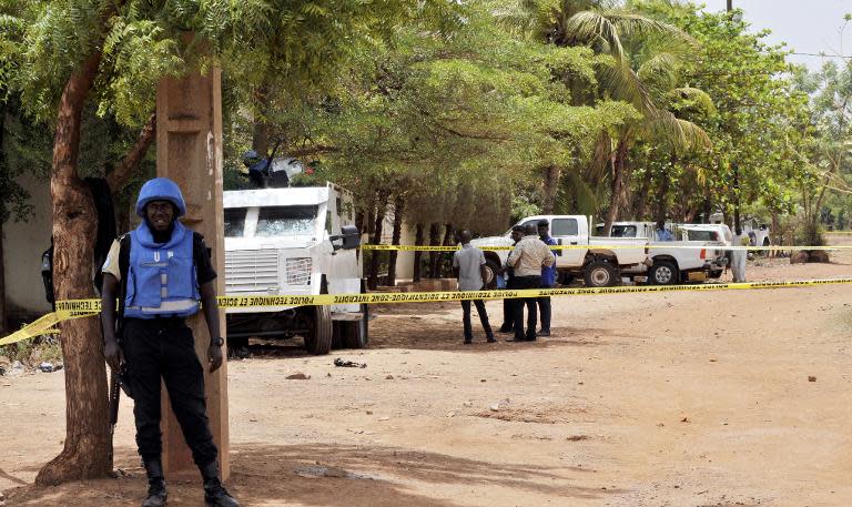 United Nations peacekeeping solders stand by a cordon set up at the site where a gunman opened fire at a UN residence in Bamako on May 20, 2015