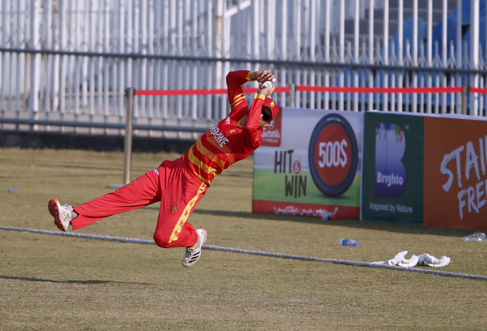 Zimbabwe's fielder Craig Ervine takes catch of Pakistani batsman Fahim Ashraf during their 1st one-day international cricket match at the Pindi Cricket Stadium, in Rawalpindi, Pakistan, Friday, Oct. 30, 2020. (AP Photo/Anjum Naveed)