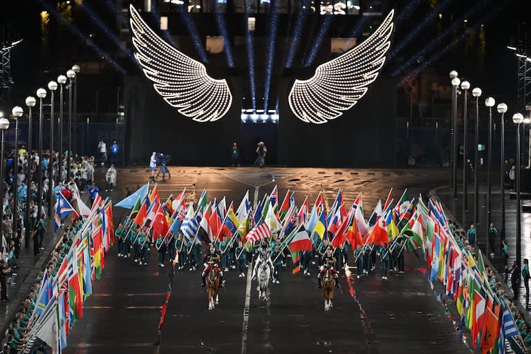 Los voluntarios llevan las banderas de las naciones participantes en el Trocadero durante la ceremonia de apertura