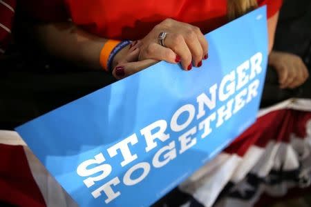 A woman wearing a wedding ring holds a sign in support of U.S. Democratic presidential nominee Hillary Clinton as Clinton and former Vice President Al Gore talk about climate change at a rally at Miami Dade College in Miami, Florida, U.S. October 11, 2016. REUTERS/Lucy Nicholson