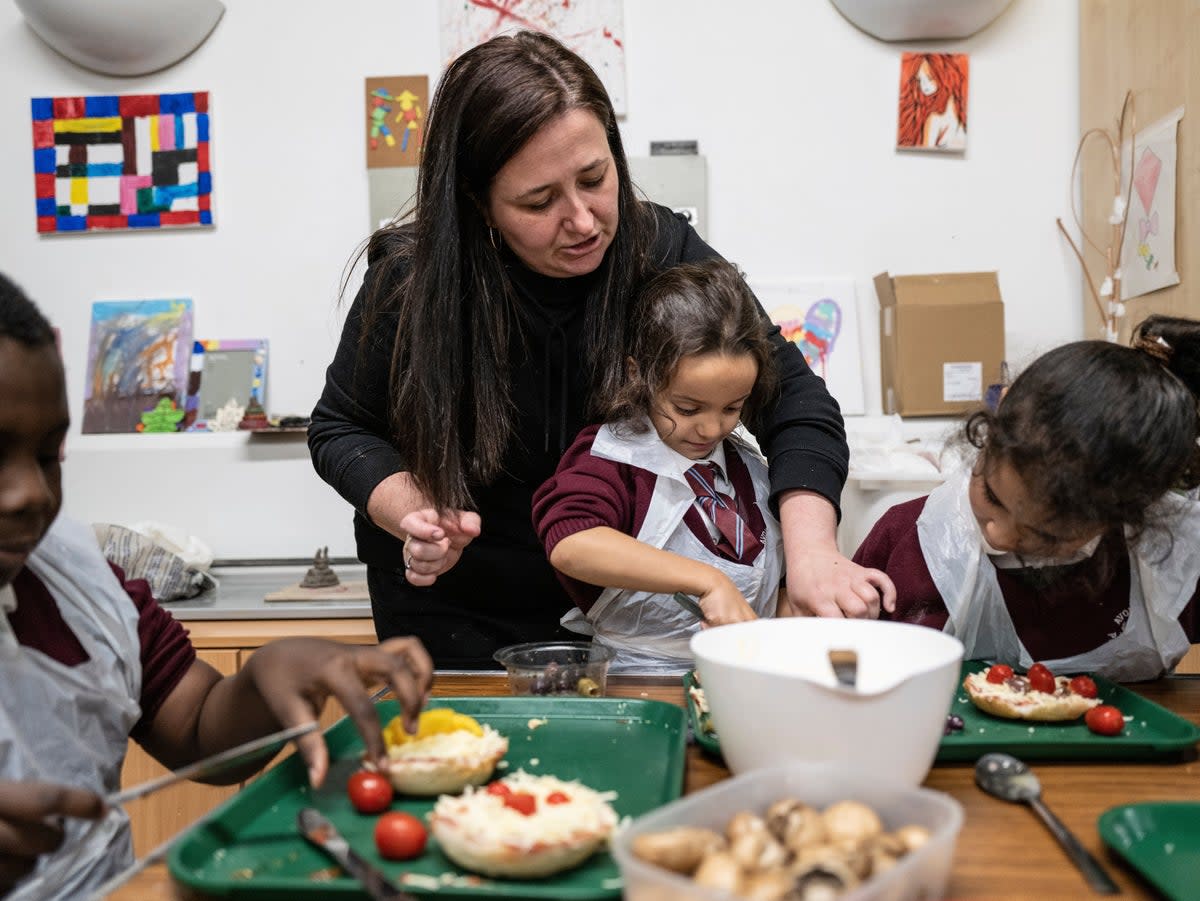 Children cooking with help from Faye Murray, the play lead at the Henry Dickens Community Centre, Shepherd's Bush. (Daniel Hambury/Stella Pictures Ltd)
