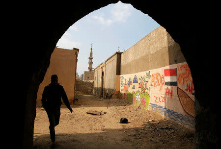 A man walks in front of a graffiti painted on a wall inside the 15th-century complex built by Mameluk Sultan al-Ashraf Qaitbey, in Cairo's City of the Dead, in Cairo's City of the Dead, Egypt February 13, 2017. REUTERS/Amr Abdallah Dalsh