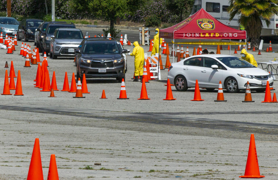 Long lines await for people who were scheduled to be tested for COVID-19 at a drive-up testing site in Elysian Park, Thursday, April 2, 2020. Officials say hand-washing and keeping a safe social distance are priorities in battling the COVID-19 virus. (AP Photo/Damian Dovarganes)