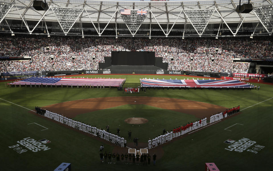 Boston Red Sox and New York Yankees players line up as flags are unfurled before a baseball game, Saturday, June 29, 2019, in London. Major League Baseball made its European debut game Saturday at London Stadium. (AP Photo/Tim Ireland)