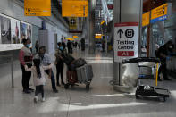 Passengers are greeted by a child as they arrive at Terminal 5 of Heathrow Airport in London, Monday, Aug. 2, 2021. Travelers fully vaccinated against coronavirus from the United States and much of Europe were able to enter Britain without quarantining starting today, a move welcomed by Britain's ailing travel industry. (AP Photo/Matt Dunham)