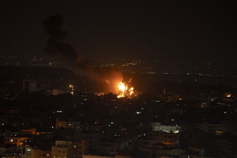 Una columna de fuego y humo se elevan al cielo durante un ataque aéreo nocturno israelí en el centro de la Franja de Gaza