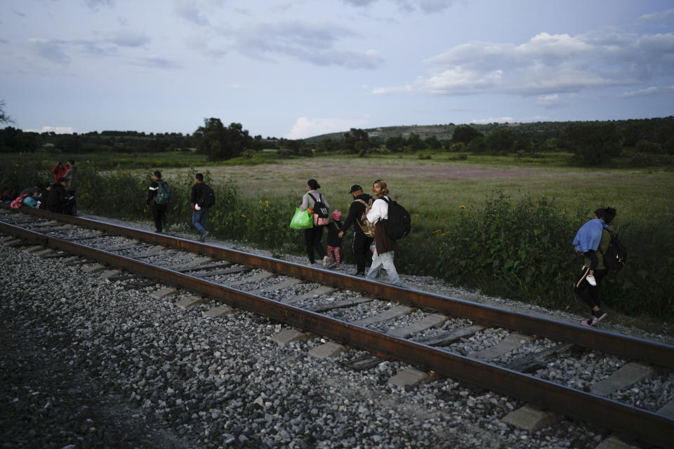 Migrants walks along a rail line hoping to board a freight train heading north, in Huehuetoca, Mexico, Sept. 19, 2023. Ferromex, Mexico's largest railroad company announced that it was suspending operations of its cargo trains due to the massive number of migrants that are illegally hitching a ride on its trains moving north towards the U.S. border. (AP Photo/Eduardo Verdugo)