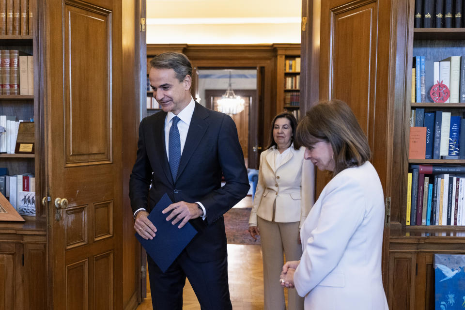 Greece's Prime Minister Kyriakos Mitsotakis, center, arrives for a meeting with Greek President Katerina Sakellaropoulou at the Presidential palace, in Athens, Saturday, April 22, 2023. Mitsotakis visited the Greek President to officially announce a general election on May 21. (AP Photo/Yorgos Karahalis)