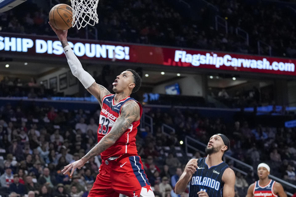 Washington Wizards forward Kyle Kuzma (33) drives to the basket past Orlando Magic guard Jalen Suggs (4) during the first half of an NBA basketball game Wednesday, March 6, 2024, in Washington. (AP Photo/Alex Brandon)