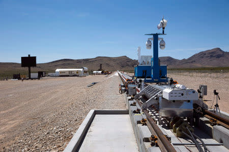 A silver-colored sled and recovery vehicle are displayed on a test track after a propulsion open-air test at Hyperloop One in North Las Vegas, Nevada, U.S. May 11, 2016. REUTERS/Steve Marcus