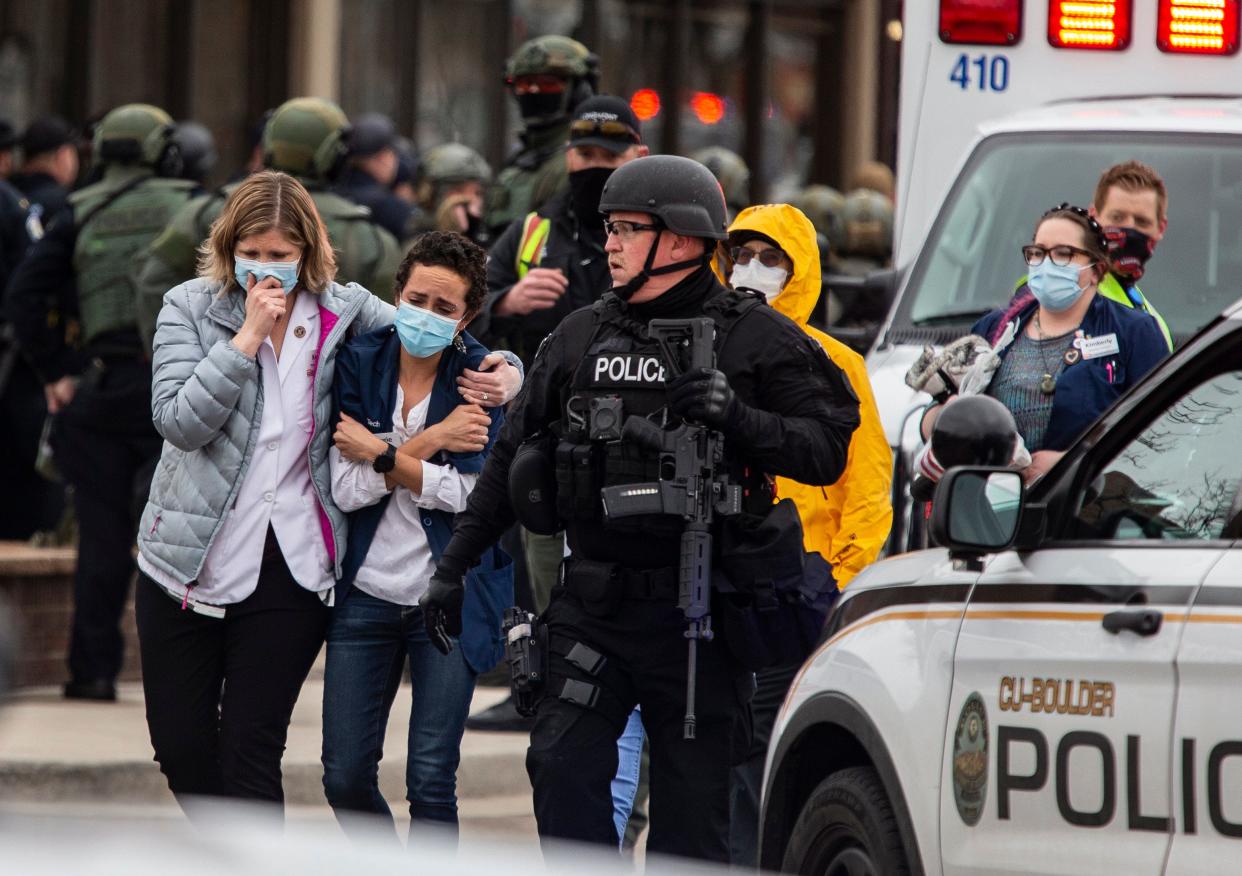 Healthcare workers walk out of a King Sooper's Grocery store after a gunman opened fire on March 22, 2021, in Boulder, Colorado. Dozens of police responded to the afternoon shooting in which at least one witness described three people who appeared to be wounded, according to published reports.