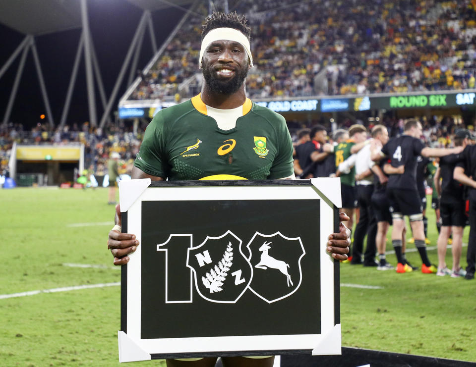South Africa's captain Siya Kolisi holds a piece of memorabilia commemorating the 100th test against the All Blacks following their Rugby Championship test match in Townsville, Australia, Saturday, Sept. 25, 2021. (AP Photo/Tertius Pickard)
