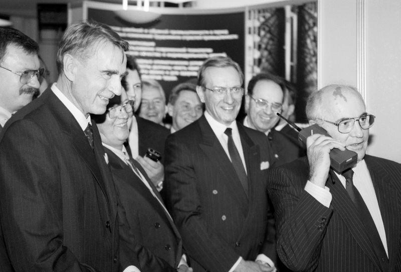 Then-Finnish President Mauno Koivisto (L) looks on as then-Soviet President Mikhail Gorbachev talks to Moscow on a Nokia Mobira Cityman cellular phone in Helsinki