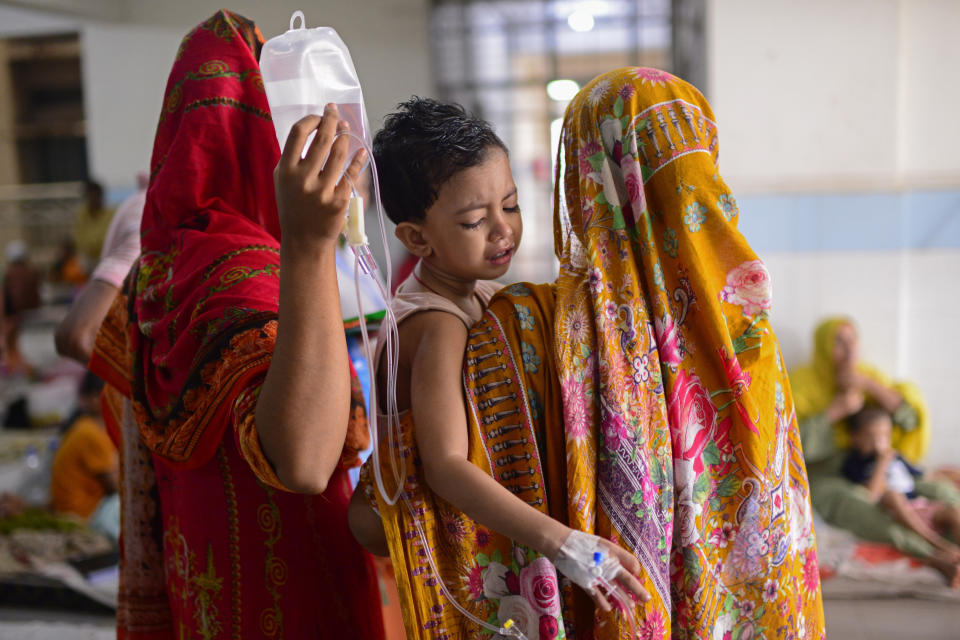 A child is carried by his mother as he receives treatment for dengue at Mugda Medical College and Hospital in Dhaka, Bangladesh, Thursday, Aug. 10, 2023. (AP Photo/Mahmud Hossain Opu)