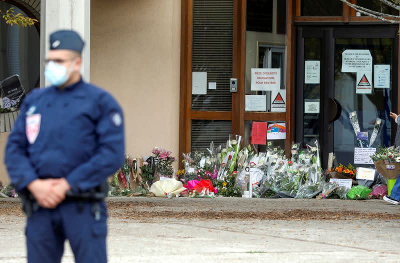 People bring flowers to the Bois d'Aulne college after the attack in the Paris suburb of Conflans St Honorine