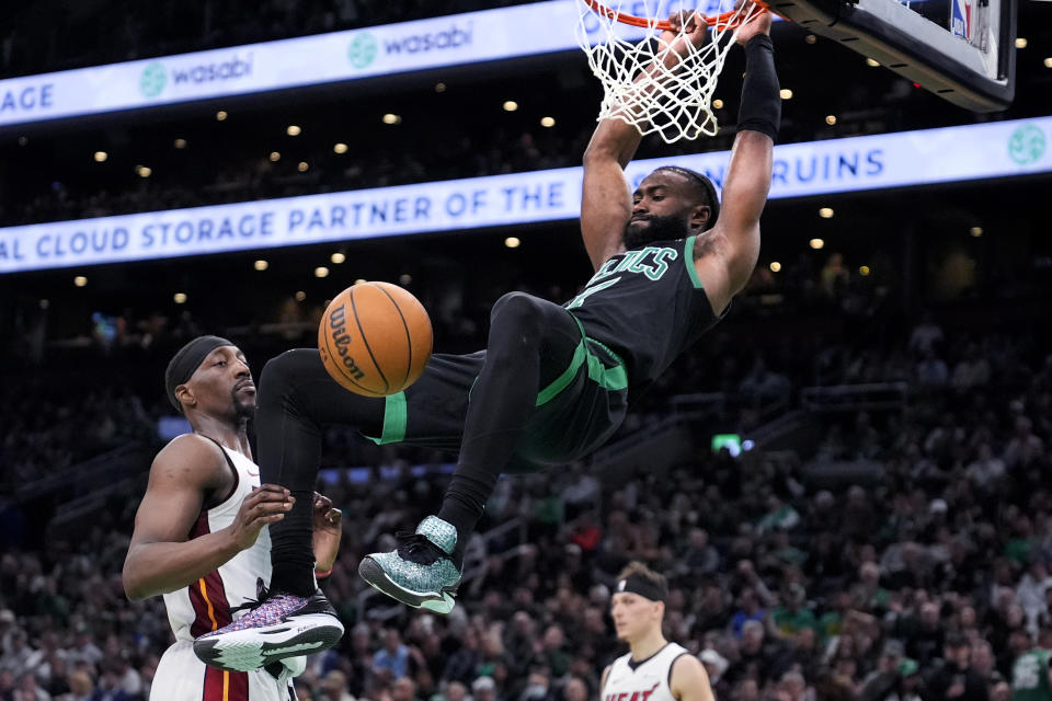 Boston Celtics guard Jaylen Brown, right, slams a dunk against Miami Heat center Bam Adebayo (13) during the first half of Game 5 of an NBA basketball first-round playoff series, Wednesday, May 1, 2024, in Boston. (AP Photo/Charles Krupa)