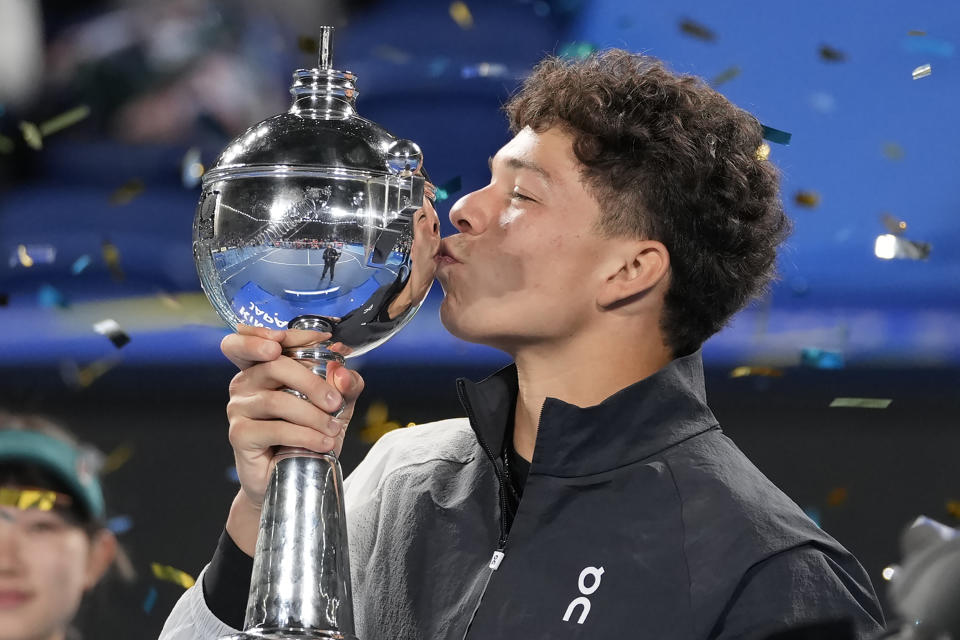 Ben Shelton of the U.S. kisses the winning trophy during the awarding ceremony, after defeating Aslan Karatsev of Russia in the men's singles final of Japan Open tennis championships in Tokyo, Japan, Sunday, Oct. 22, 2023.(AP Photo/Shuji Kajiyama)