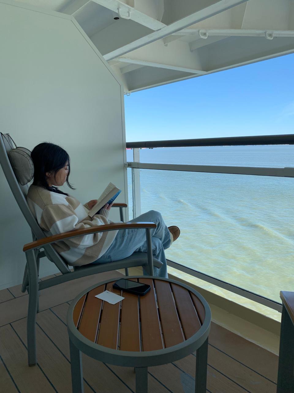 woman reading on cruise balcony