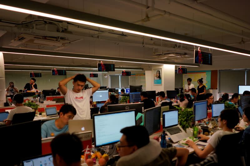 FILE PHOTO: Employees work at DingTalk office, an offshoot of Alibaba Group Holding Ltd, in Hangzhou