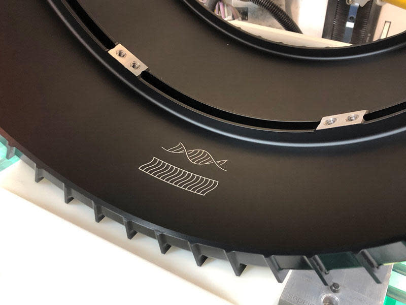 This photo shows two small drawings inscribed inside the front left wheel of the Mars Perseverance rover, pictured here before it was installed on the rover. One figure represents the tracks that the rover leaves as it drives on Mars. The other resembles that same pattern, twisted into the shape of DNA.  / Credit: NASA/JPL-Caltech