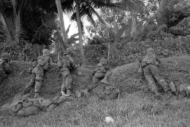 U.S. Marines, armed with M16A1 rifles, take defensive positions October 25, 1983, along a hillside during Operation Urgent Fury, the United States-led invasion of Grenada following a coup in the tiny Caribbean country. File Photo by USMC/UPI