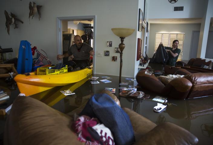 The Kosers’ son Larry Jr. and their grandson Matthew look for important papers and heirlooms in the flooded house. (Photo: Erich Schlegel/Getty Images)