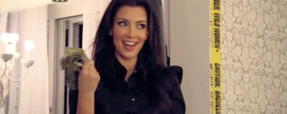 A woman smiling and fanning herself with money