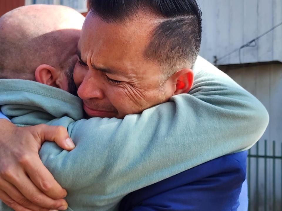 Jimmy Lippert Thyden cries as he hugs one of his brothers for the first time in Valdivia, Chile, on Aug. 17, 2023.