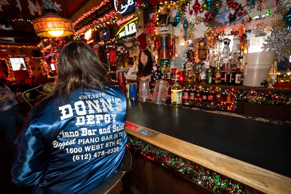 Michelle Beebe, a bartender and venue manager at Donn's, sits at the bar. "None of it is possible without the people that come in and make it," Beebe says of the holiday decor.