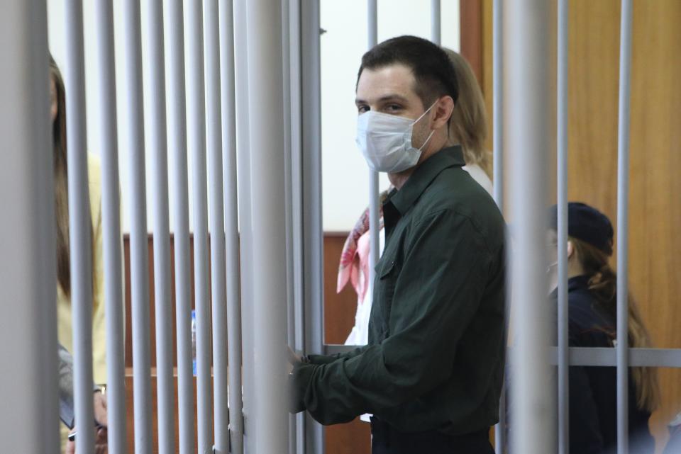 FILE - U.S. Marine veteran Trevor Reed stands behind bars in a courtroom in Moscow, Russia, on Monday, July 20, 2020. Arrests of Americans in Russia have become increasingly common as relations between Moscow and Washington sink to Cold War lows. Some have been exchanged for Russians held in the U.S., while for others, the prospects of being released in a swap are less clear. (Andrei Nikerichev/Moscow News Agency via AP, File)