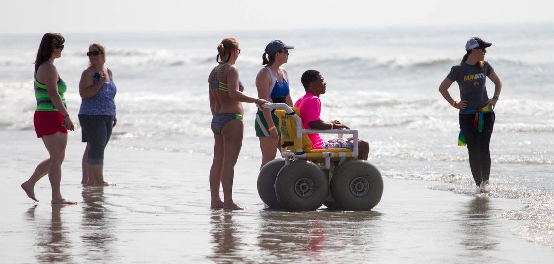 A surfer waits in a beach wheel chair for a chance to hit the waves at the “Wheel to Surf” Adaptive Surfing Clinic held in North Myrtle Beach on Saturday. Forty participants with mental and physical disabilities took to the water with help from over 100 volunteers. “Today is a life changing experience for most of us,” said Brock Johnson, founder of “Wheel to Surf.” The clinic was hosted with support from Coastal Adaptive Sports, Ocean-Cure, and the Adaptive Sports Project.
