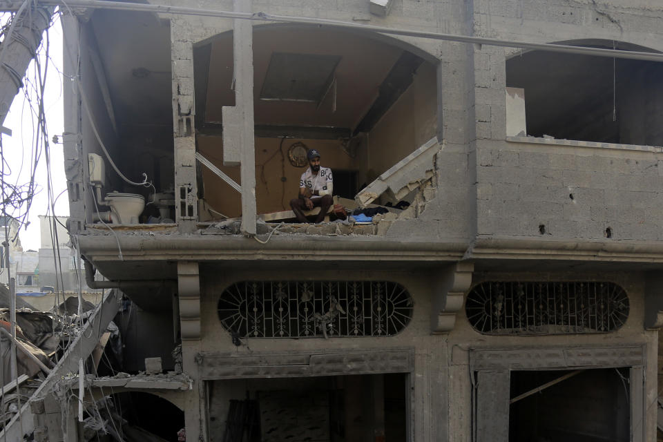 FILE - A Palestinian man watches as others inspect the damage to destroyed houses after Israeli airstrikes on Gaza City, Tuesday, Oct. 24, 2023. Hundreds of thousands of Palestinians have decided to stay in their homes in northern Gaza despite Israeli warnings that they are facing grave danger if they don't move to an evacuation zone in the southern part of the territory. (AP Photo/Abed Khaled, File)