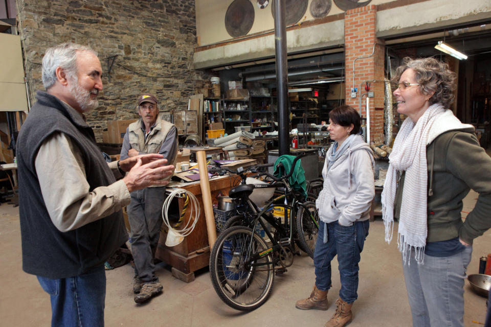 This Dec. 3, 2012, photo provided by Craft Emergency Relief Fund (CERF+) Craig Nutt,far left, of CERF+ talks to three artists at Pier Glass in the Red Hook neighborhood of Brooklyn, New York, from left, Kevin Kutch, Alison Ruzsa and Mary Ellen Buxton-Kutch. Pier Glass received a $3,000 grant from CERF. After beig nundated with salt water from Superstorm Sandy, the studio estimates the damage at up to $200,000. They received a $3,000 grant from CERF+. (AP Photo/CERF+, George Hirose)