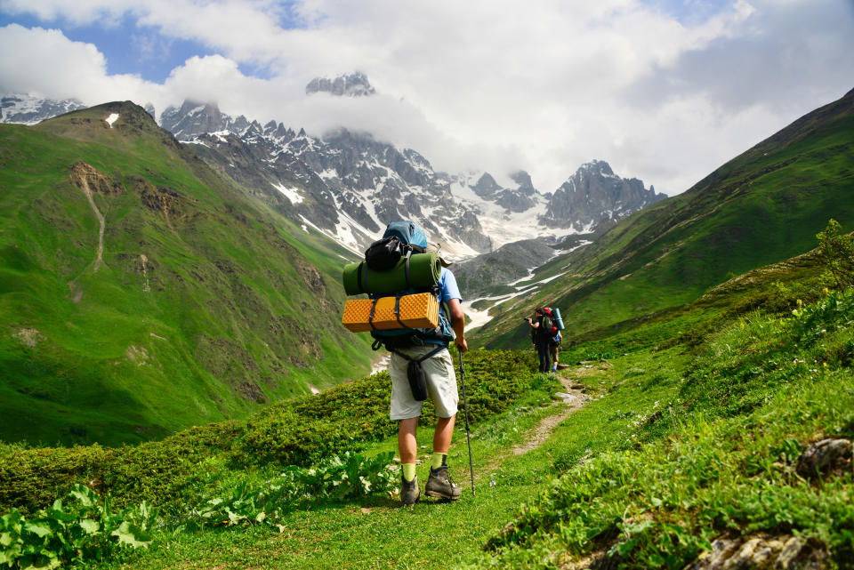 Man with hiking backpack climbs the mountains of Tbilisi.