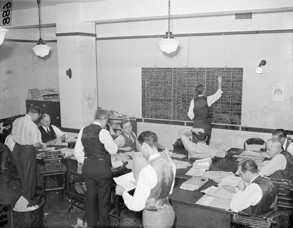 Associate Press journalists in the Washington bureau tabulate election returns, Nov. 5, 1940, keeping the score on both electoral and popular votes for the nation. The staff handled returns which flooded in over an 85,000-mile wire network. Standing is Brian Bell, left, chief of bureau for Washington, D.C. seated with back to camera is William L. Beale, Washington news editor. (AP Photo)