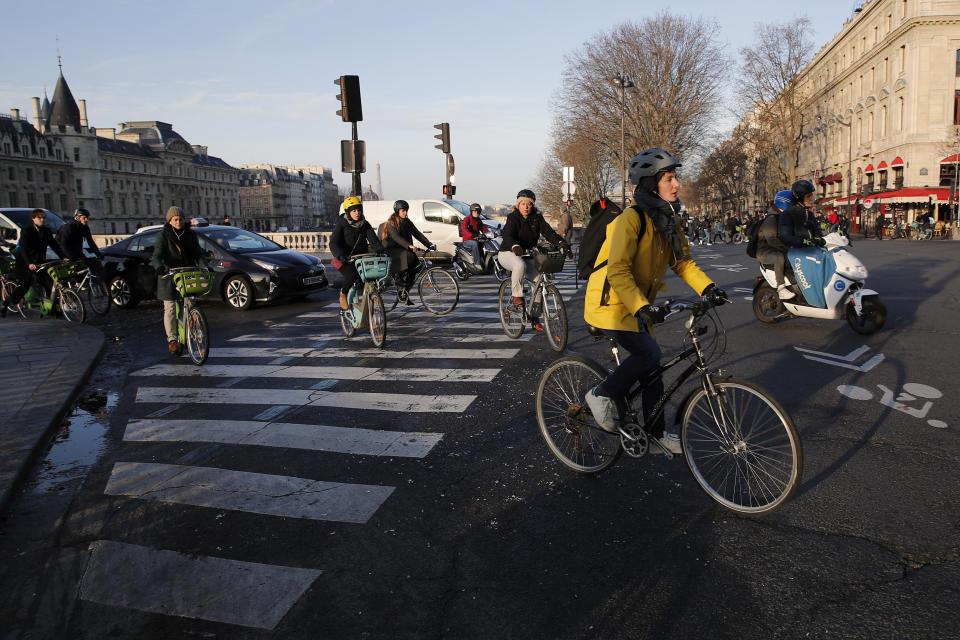 Parisians ride bicycles Tuesday, Dec. 10, 2019 in Paris. Only about a fifth of French trains ran normally Tuesday, frustrating tourists finding empty train stations, and most Paris subways were at a halt. French airport workers, teachers and others joined nationwide strikes Tuesday as unions cranked up pressure on the government to scrap changes to the national retirement system. (AP Photo/Francois Mori)