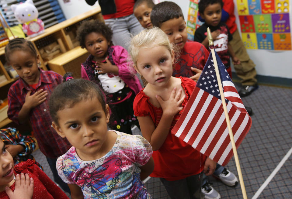 WOODBOURNE, NY - SEPTEMBER 20: Children recite the Pledge of Allegiance at the beginning of the school day at the federally-funded Head Start school on September 20, 2012 in Woodbourne, New York. The school provides early education, nutrition and health services to 311 children from birth through age 5 from low-income families in Sullivan County, one of the poorest counties in the state of New York. The county Head Start Program was expanded with a $1 million grant from President Obama's 2009 stimulus bill, the American Recovery and Reinvestment Act. Head Start, administered by the U.S. Department of Health and Human Services, is the longest-running early education program for children of low-income families in the United States. (Photo by John Moore/Getty Images)