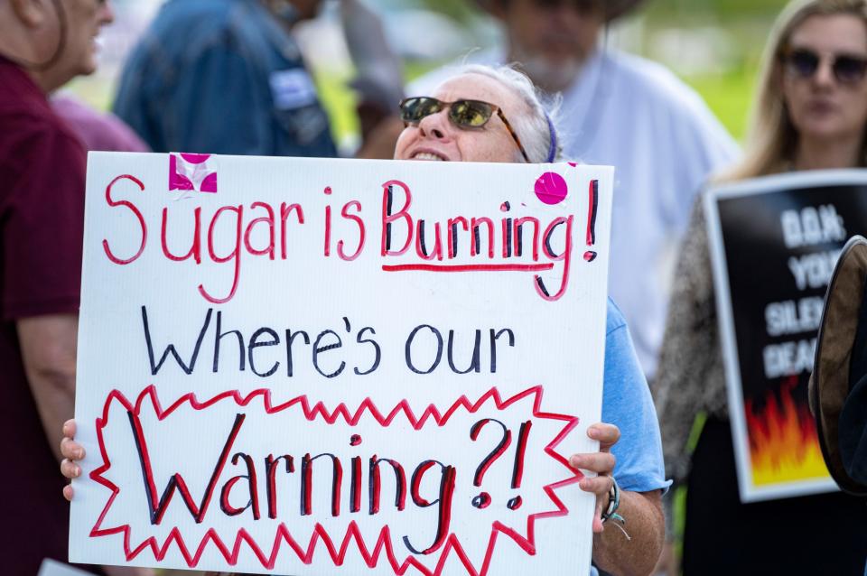 People protest outside the Palm Beach County Department of Health to demand action on health impacts from sugarcane field burning in the Glades.